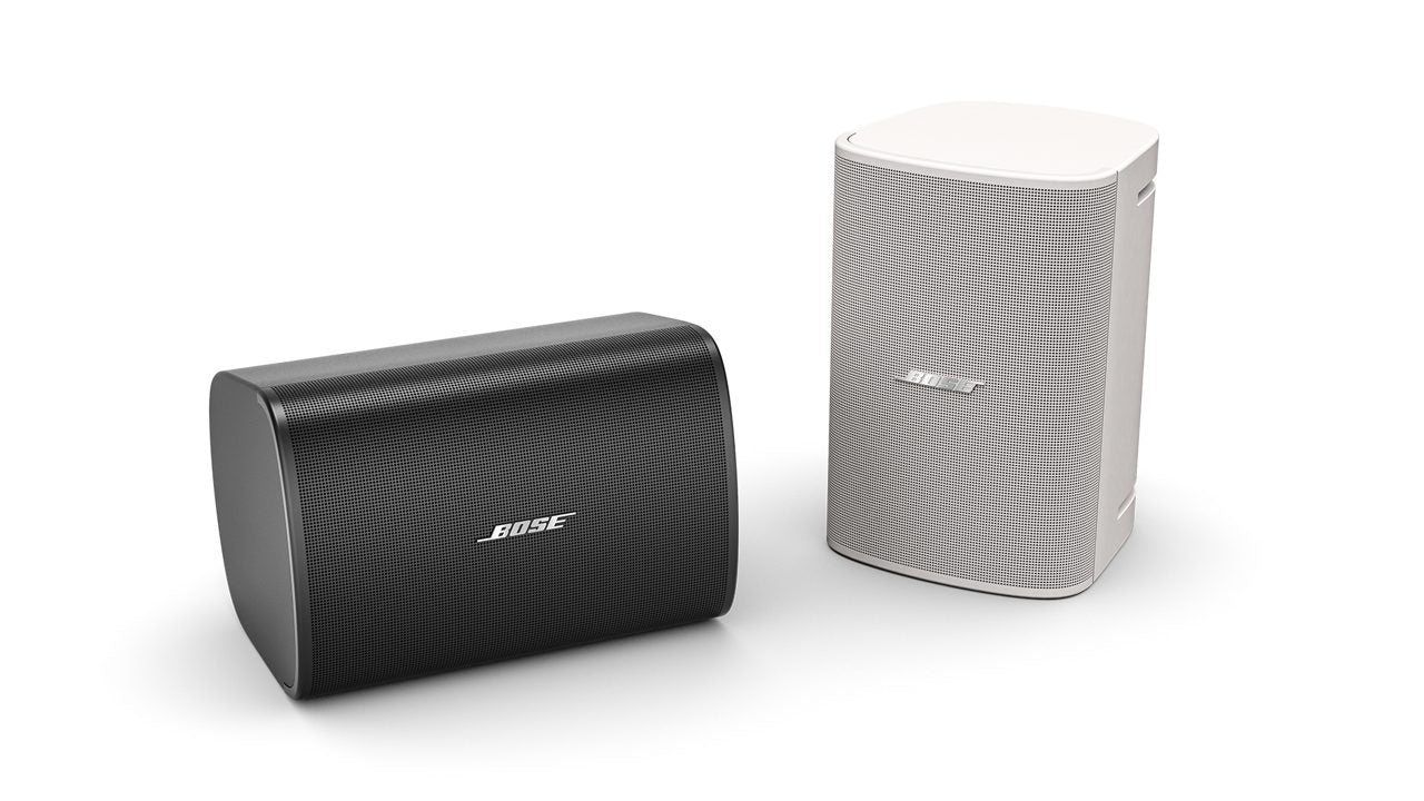 Altavoces Bose DesignMax DM5SE en acabados blanco y negro, mostrando su rejilla resistente a la intemperie y sistema de montaje flexible.