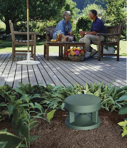 Instalación de altavoz Bose FS360P en un jardín residencial, mimetizado entre la vegetación y el césped para proporcionar audio ambiental profesional de forma discreta.