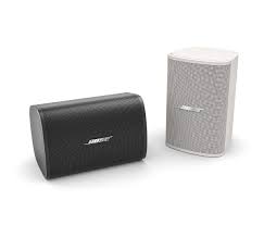 Comparativa de los altavoces de superficie Bose Professional DesignMax DM3SE, mostrando las dos opciones de color disponibles: negro mate y blanco texturizado, con sus respectivos soportes de instalación.