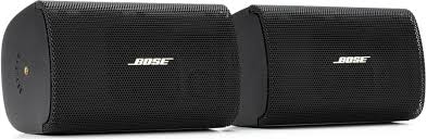 Dos bocinas comerciales de superficie Bose Professional FreeSpace FS2SE en color negro mate, mostradas en par de fábrica con sus soportes de pared en U instalados para montaje vertical y horizontal.