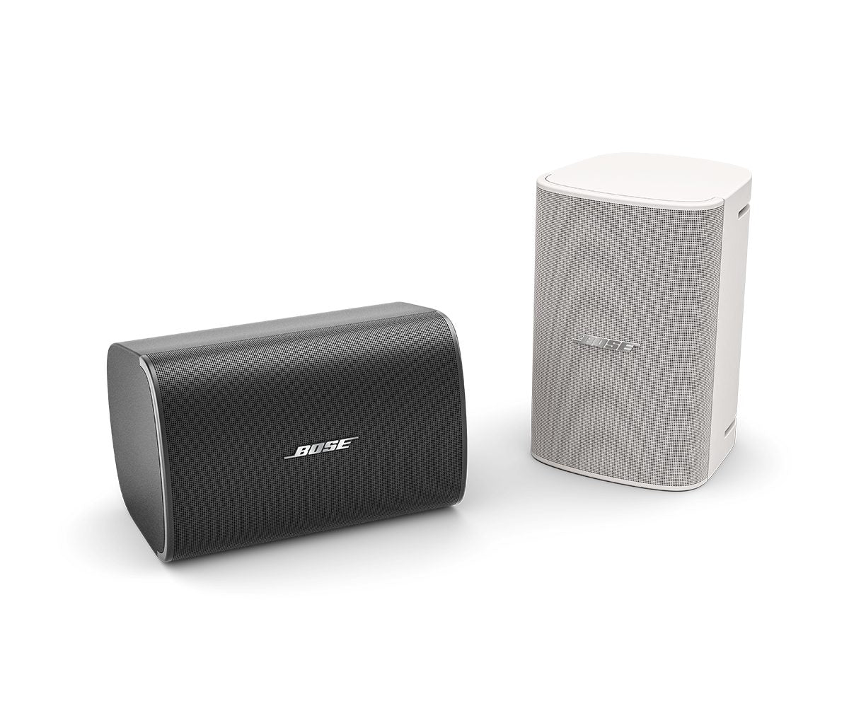 Pareja de altavoces Bose DesignMax DM6SE en acabados blanco y negro, mostrando su diseño robusto para montaje en superficie tanto en interiores como en exteriores.